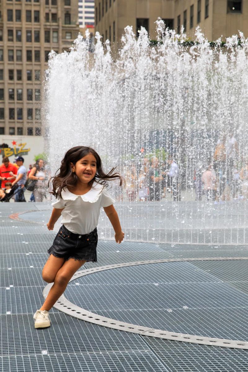 Girl surrounded by a water sprinkler