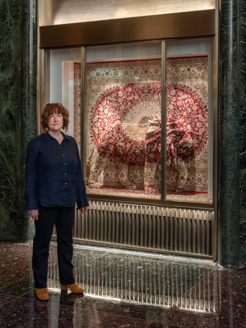 Debbie Lawson standing in front of a vitrine with a lion sculpture inside