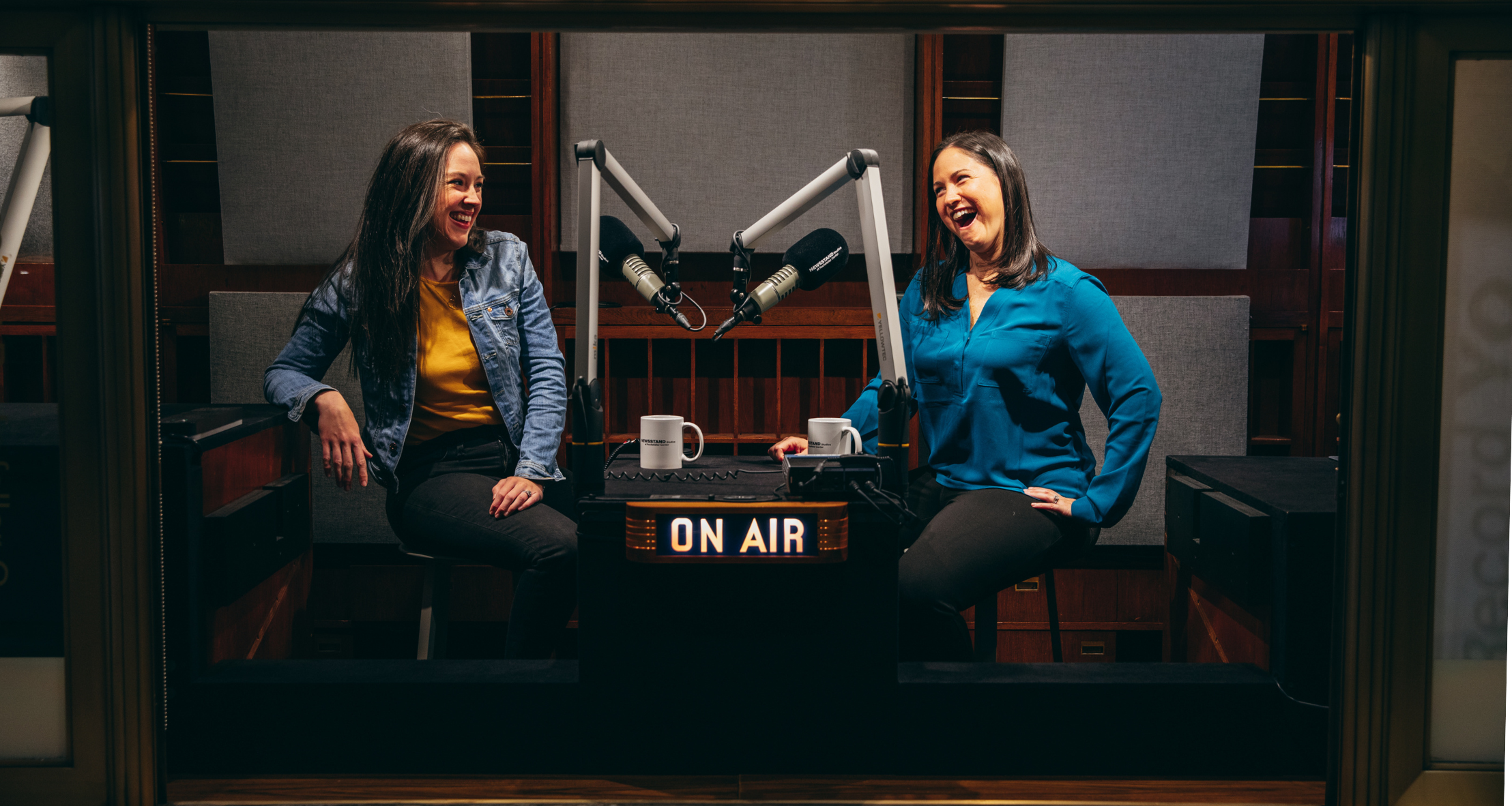 Pamela Riley and Sarah Armstrong-Brown laughing while recording a podcast