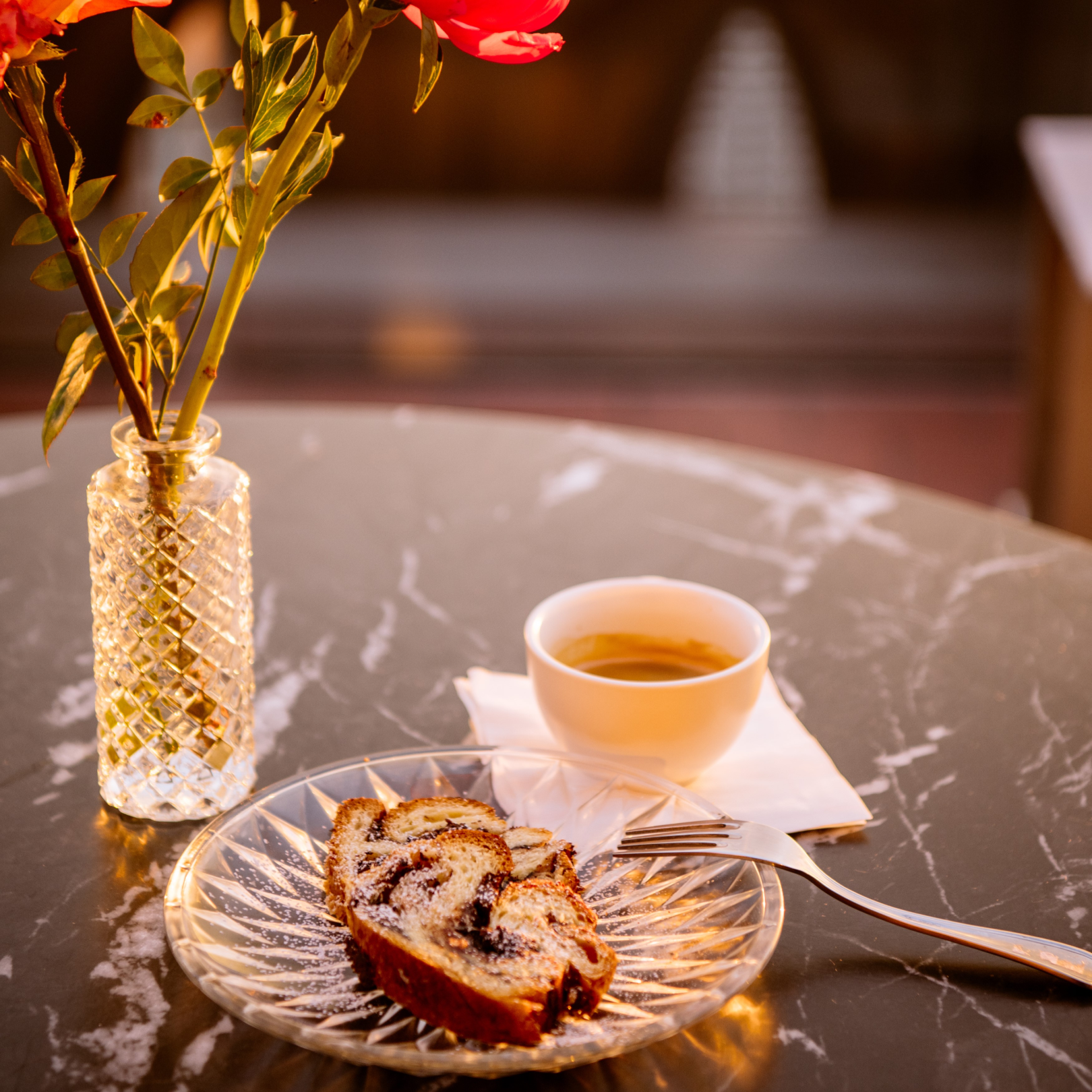 A cup of coffee and pastry on a table at The Weather Room at Top of the Rock