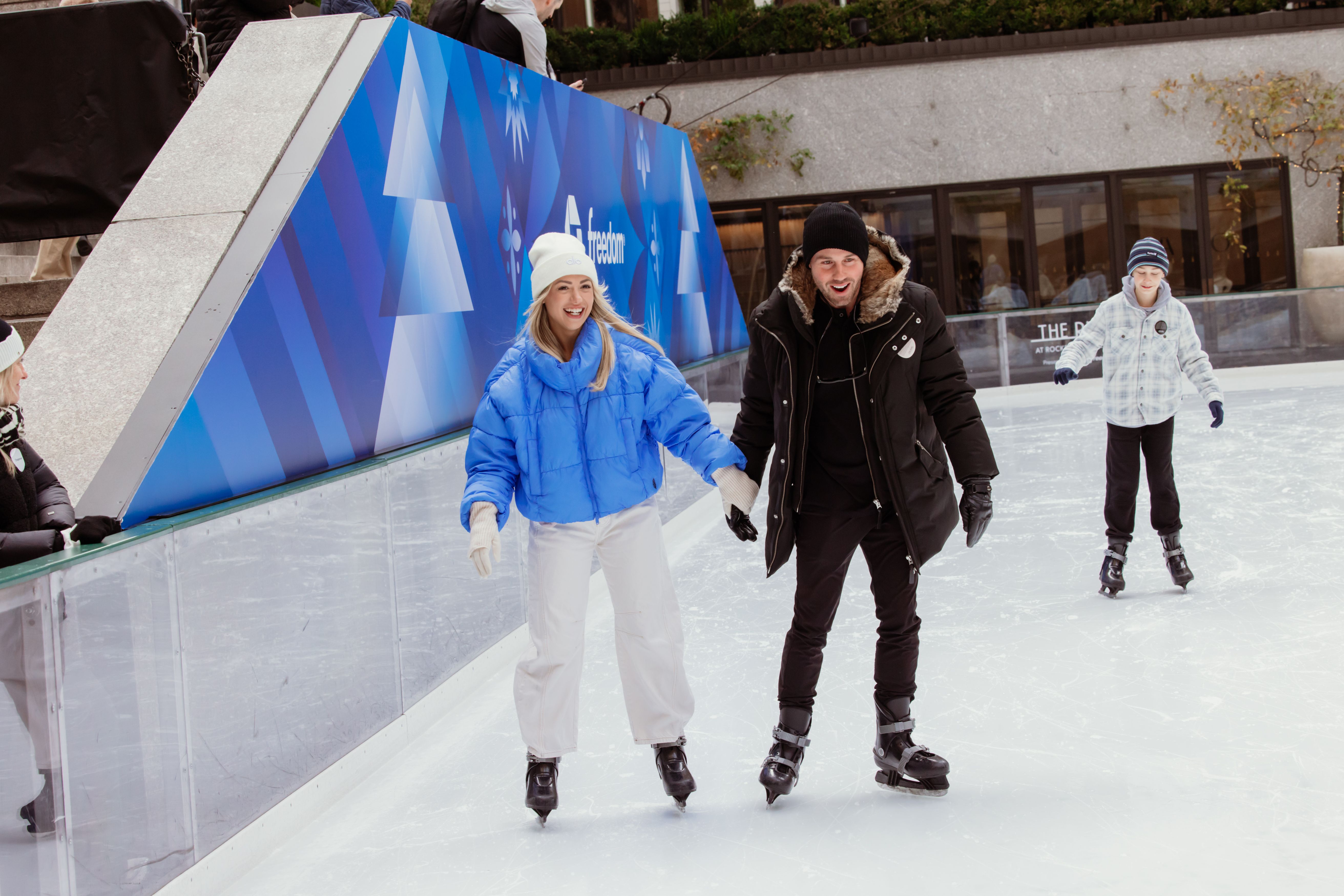 Two people skating and holding hands