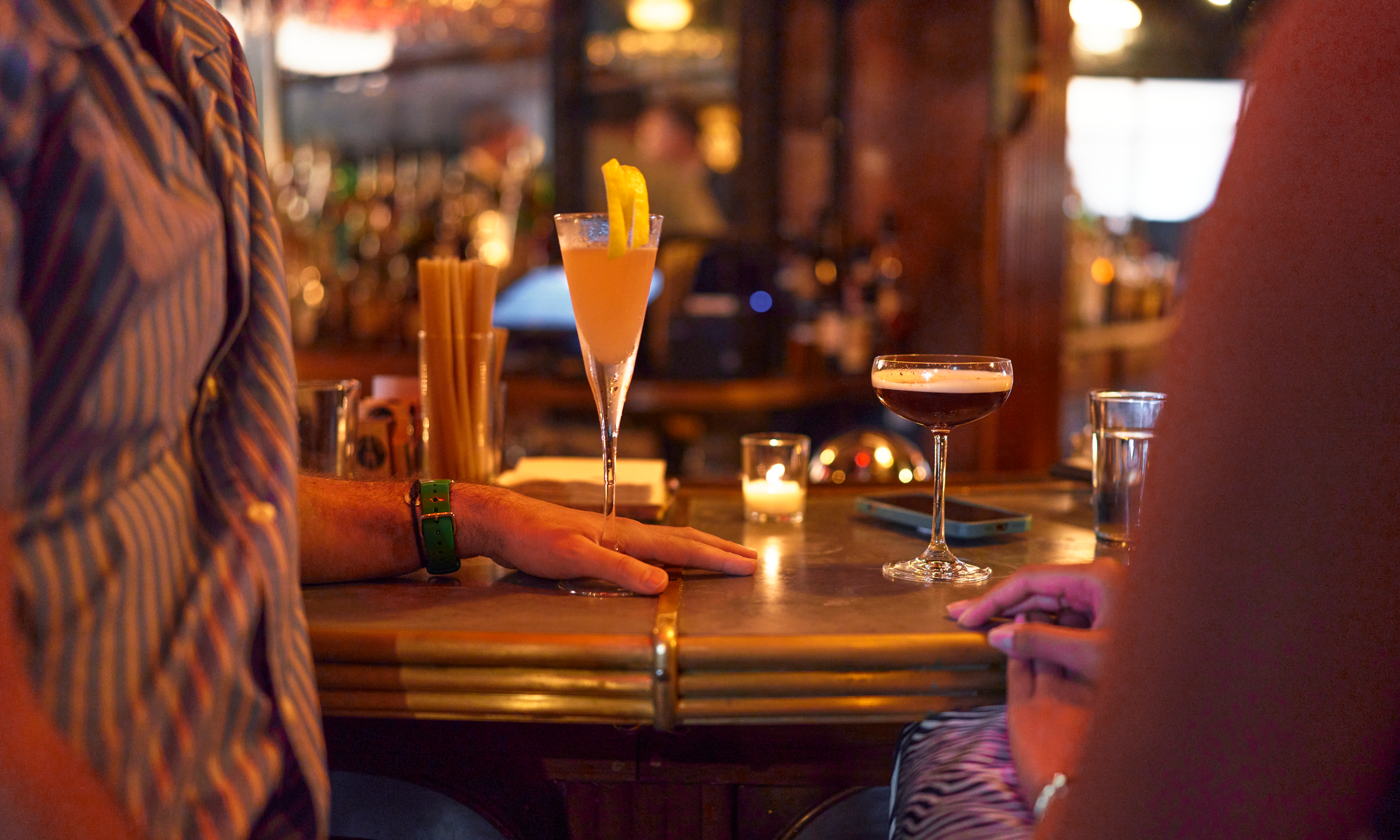 Two cocktails sitting resting on the bar at Smith & Mills