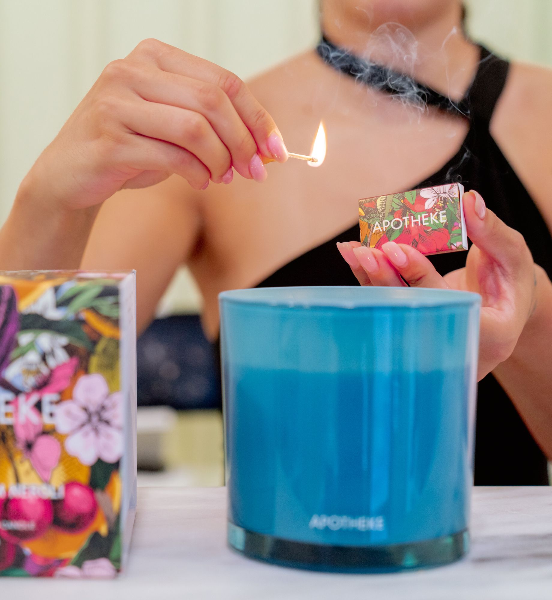 Person lighting an APOTHEKE candle