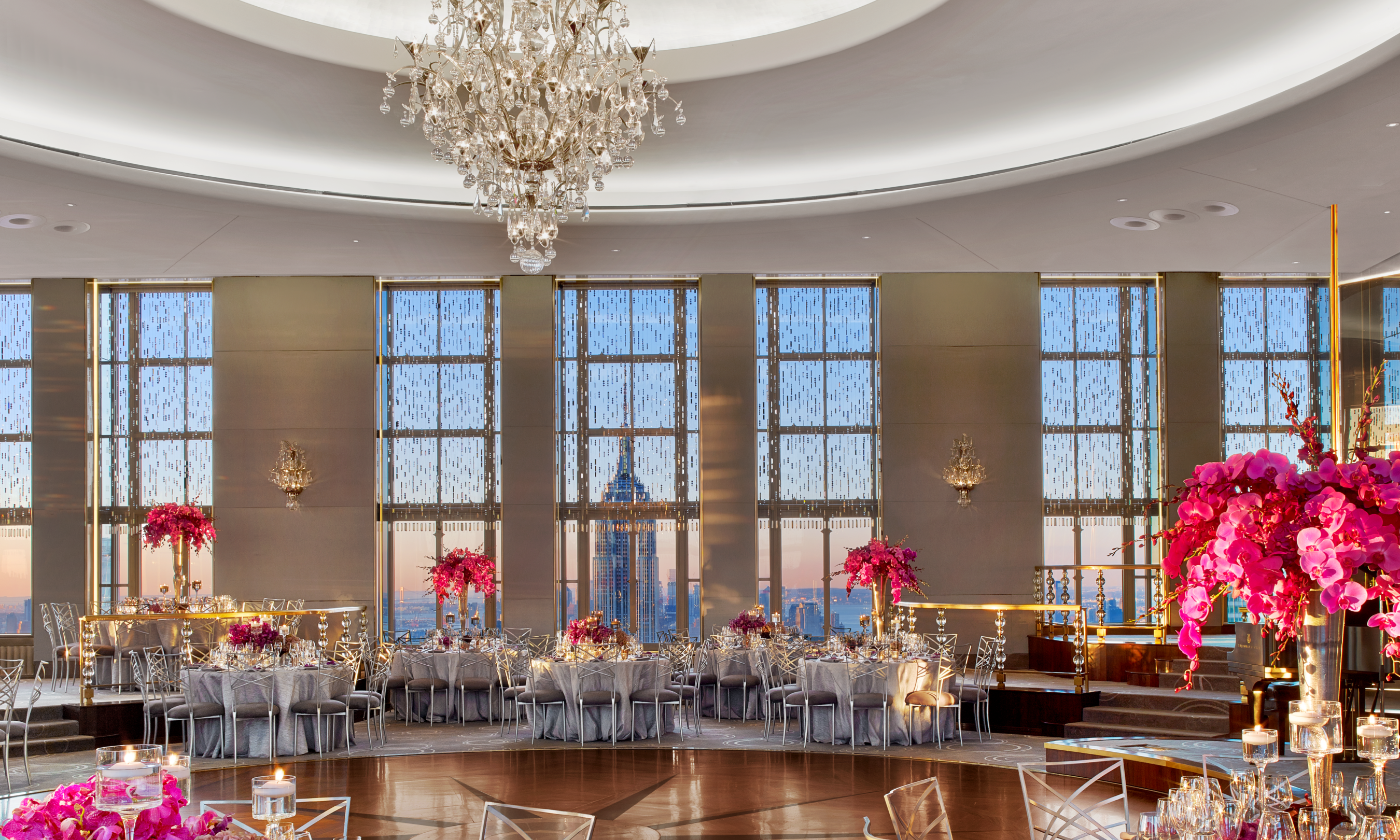 Chairs and tables decorated with pink flowers inside the Rainbow Room