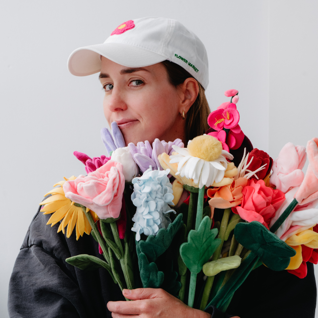 Artist Cj Hendry hugging a bouquet of her plush flower designs