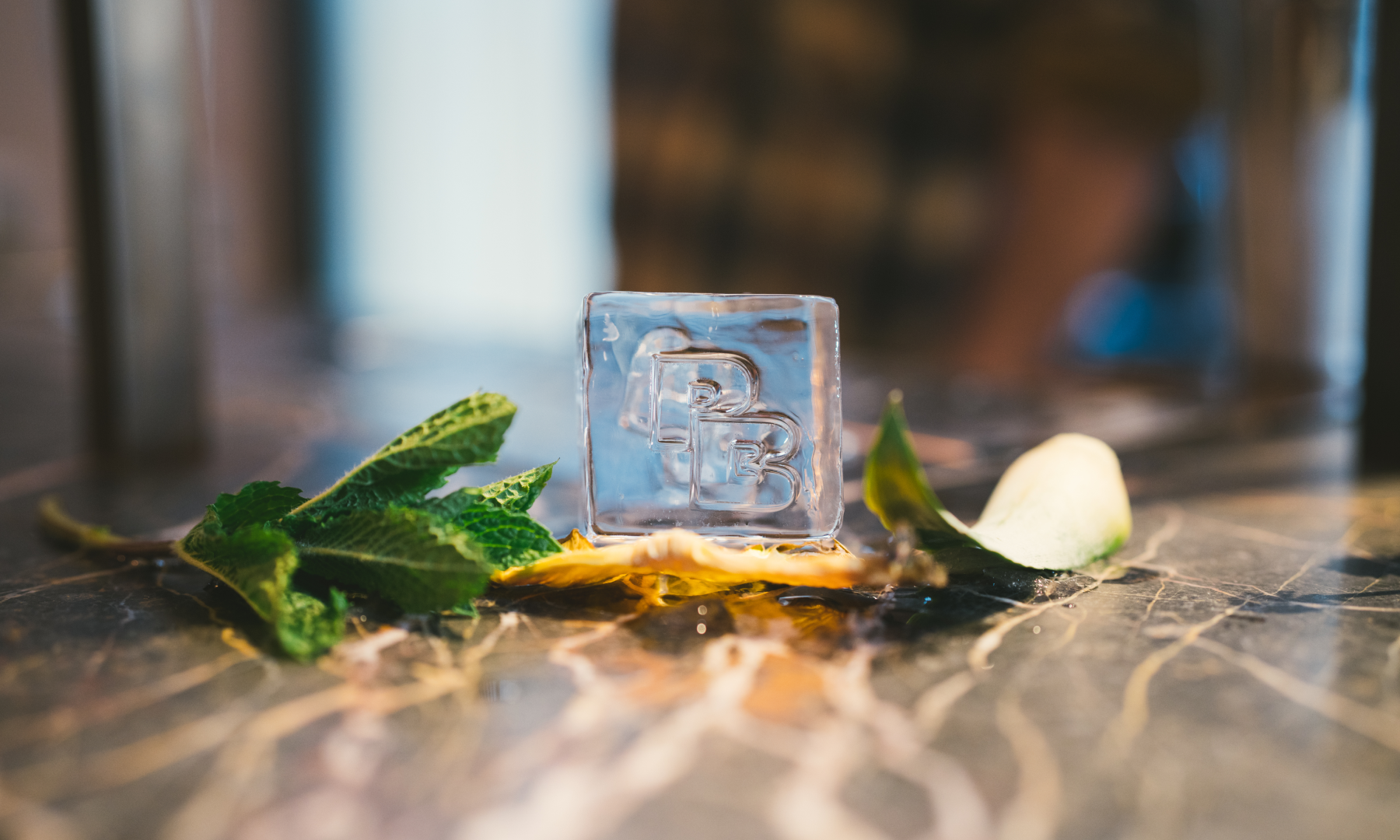 A Pebble Bar-branded ice cube on a bar counter
