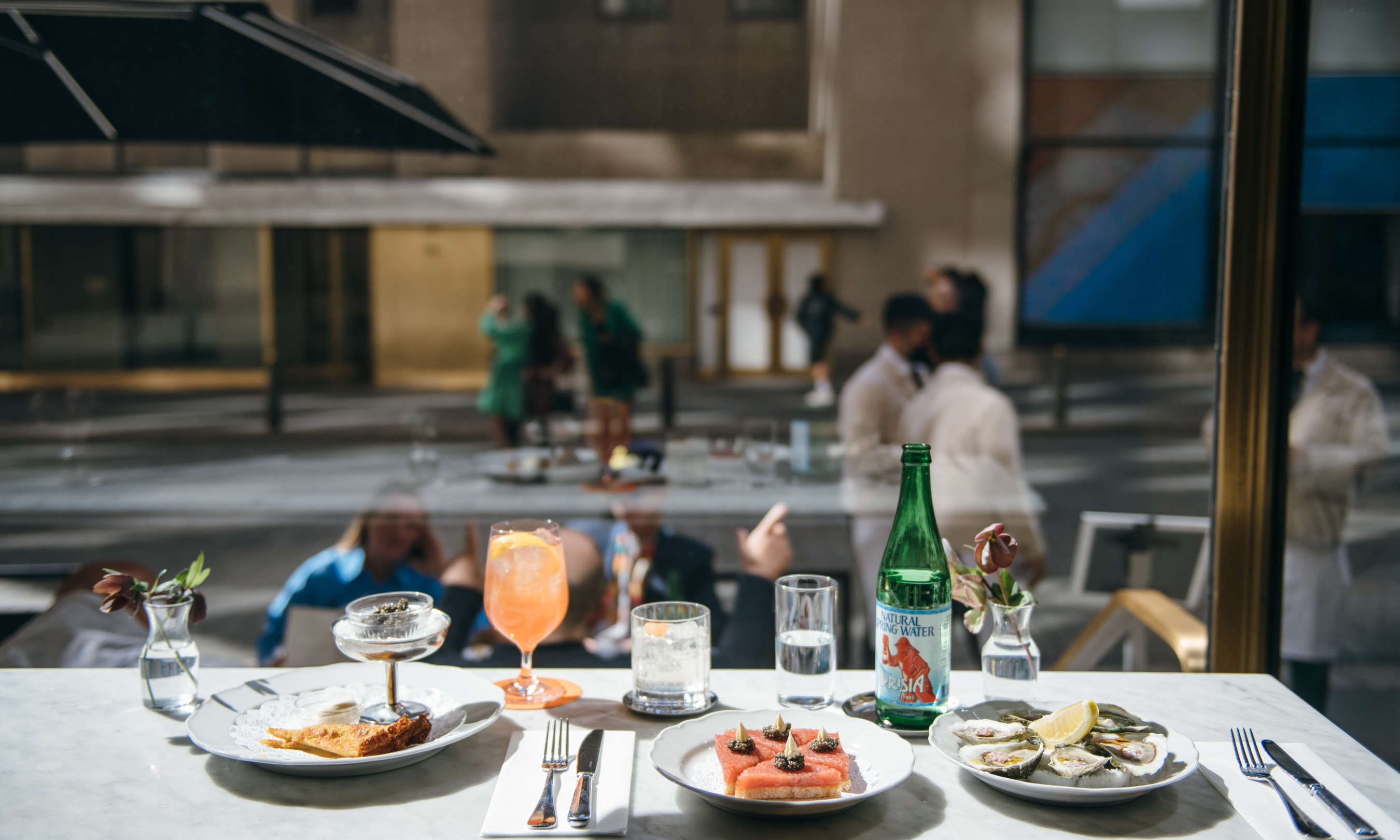 Plates of food and cocktails on a bar table at Lodi