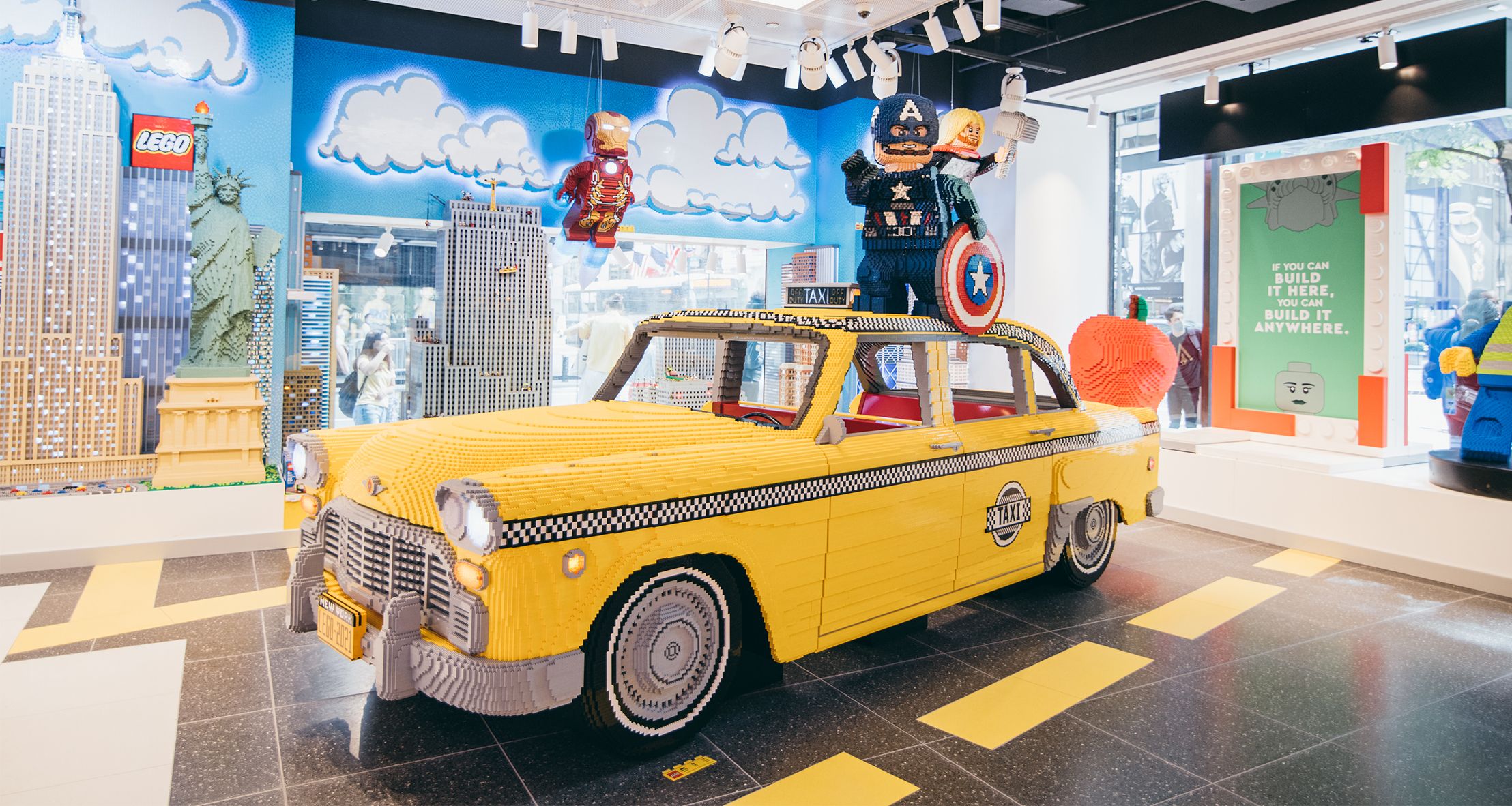 A life-size taxi cab and LEGO Marvel characters seen built out of LEGO pieces