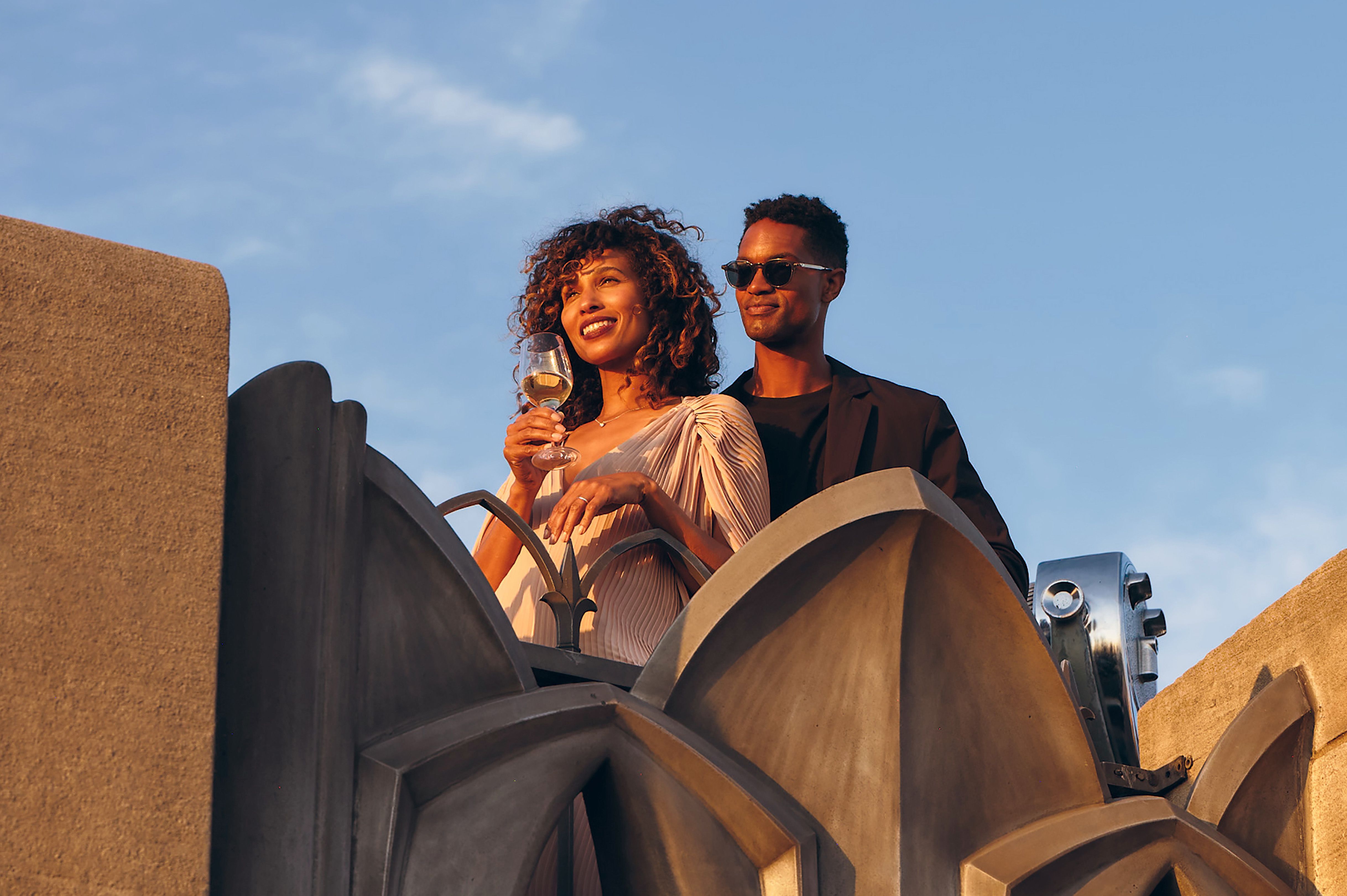 Man and woman riding Skylift at sunset overlooking the skyline