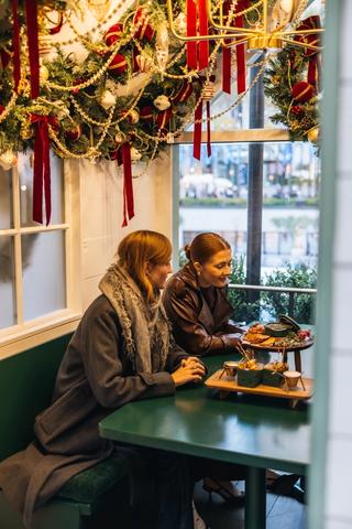 Friends seated in an Apres Skate Chalet at the Rink at Rockefeller Center