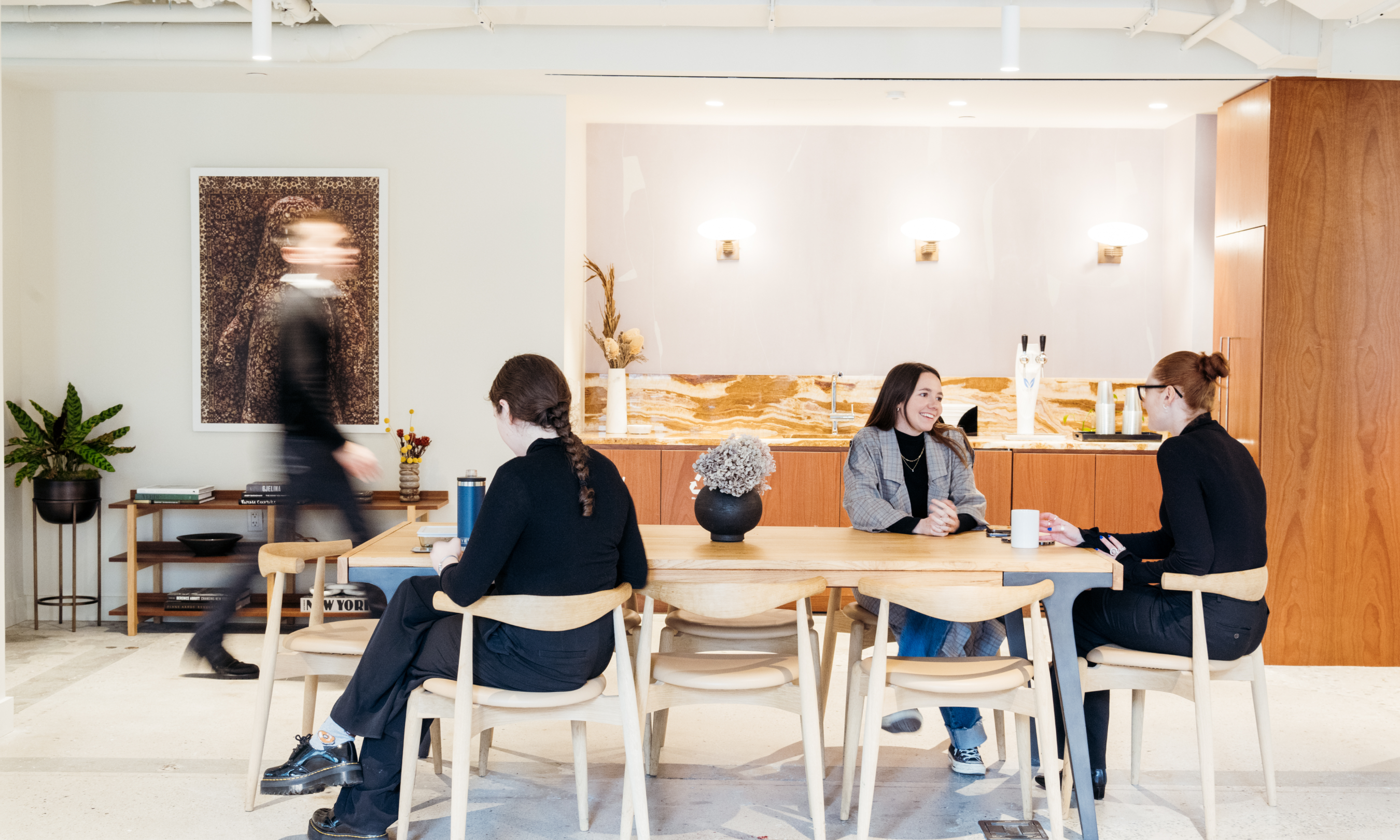 Group of people sitting at a table next to the bar area in the Radio Park West Lounge