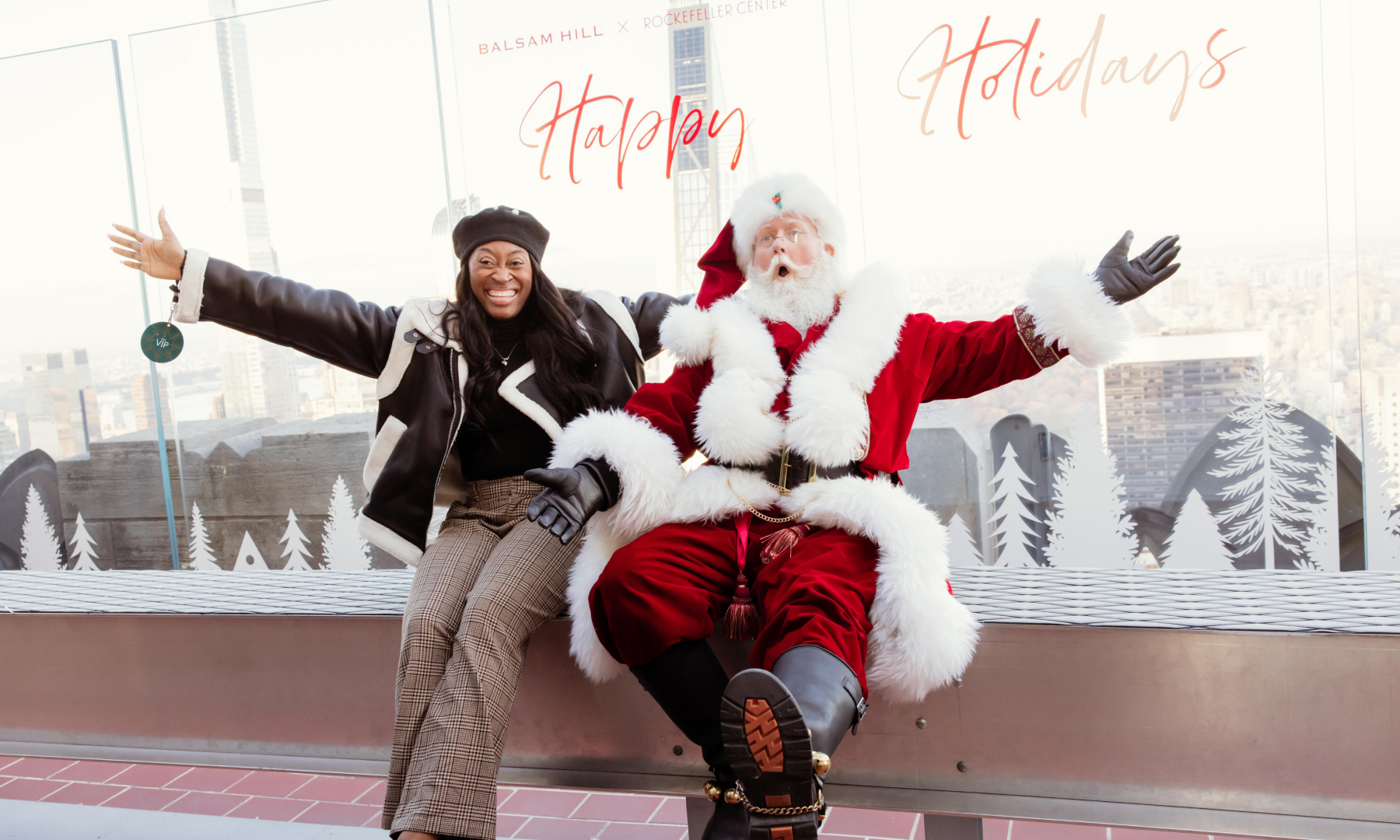 A woman posing for a photo with Santa on The Beam at Top of the Rock