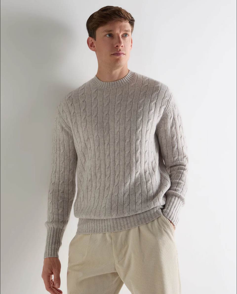 man in a gray cable knit sweater