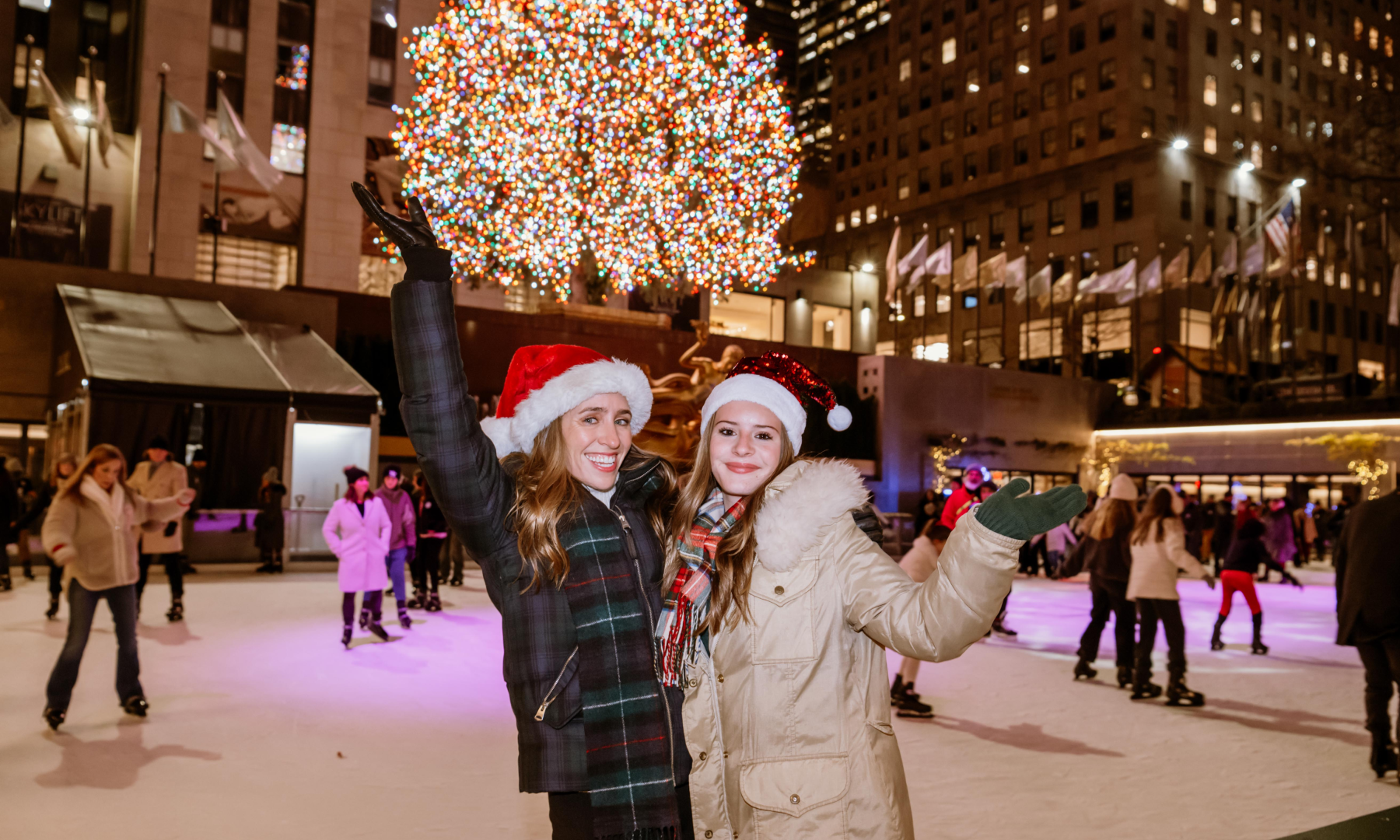 Two women posing for a photo at The Rink at Rockefeller Center