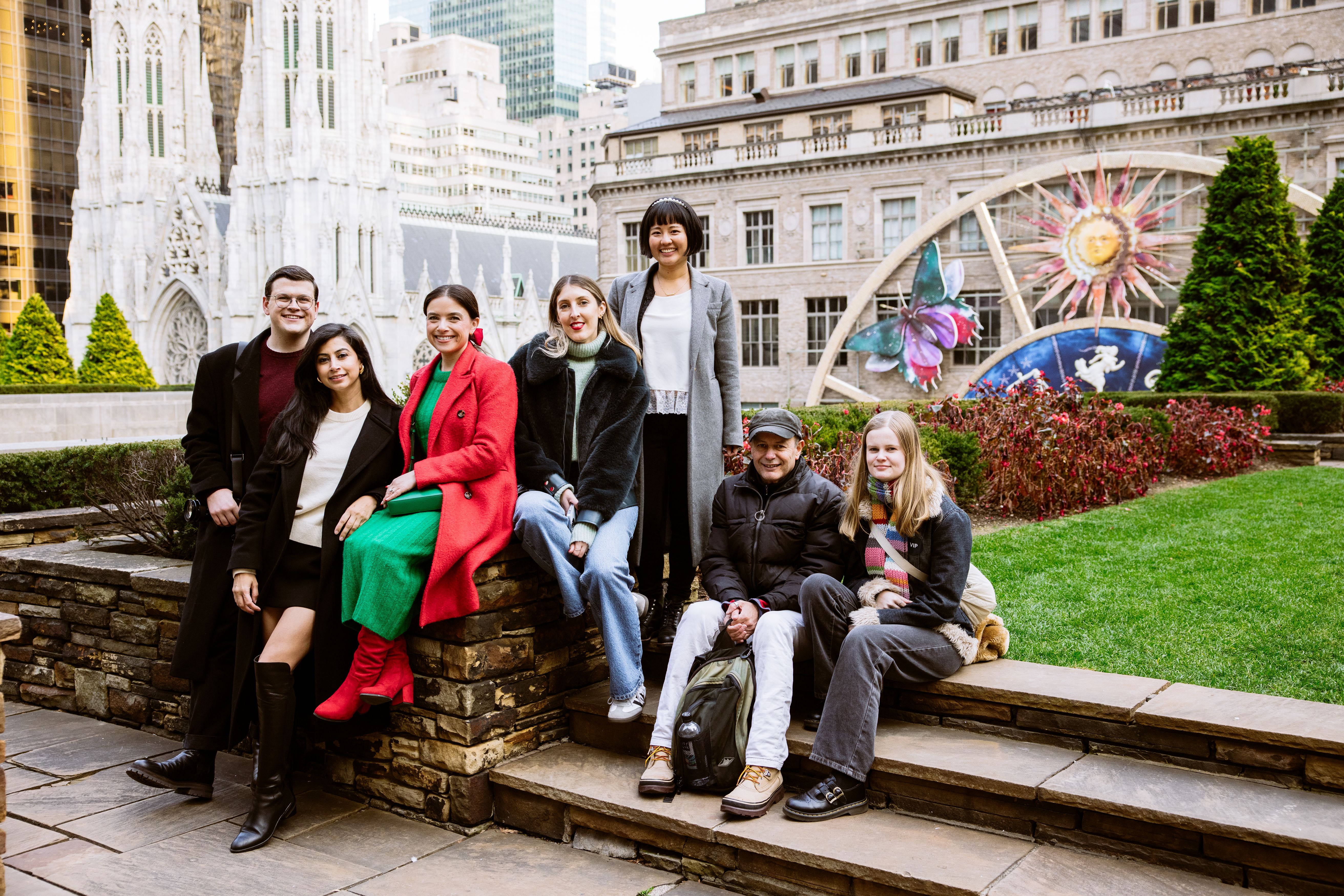 group of people sitting in front of Saks Fifth Avenue