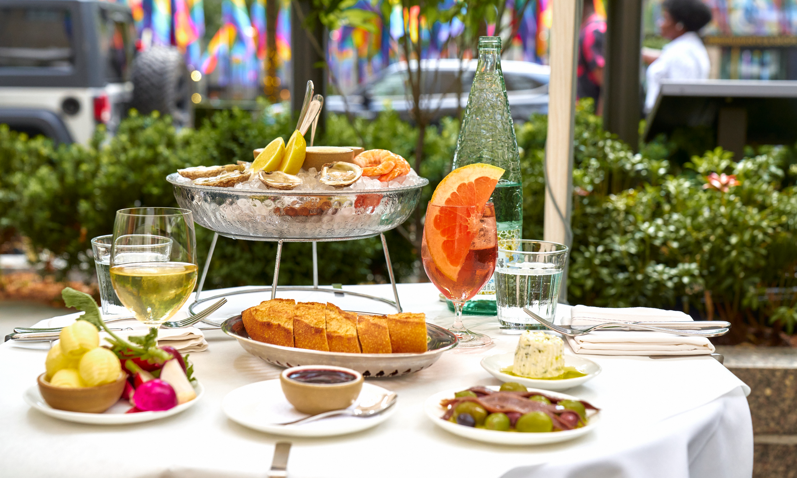 Various dishes and cocktails on an outdoor table at Le Rock