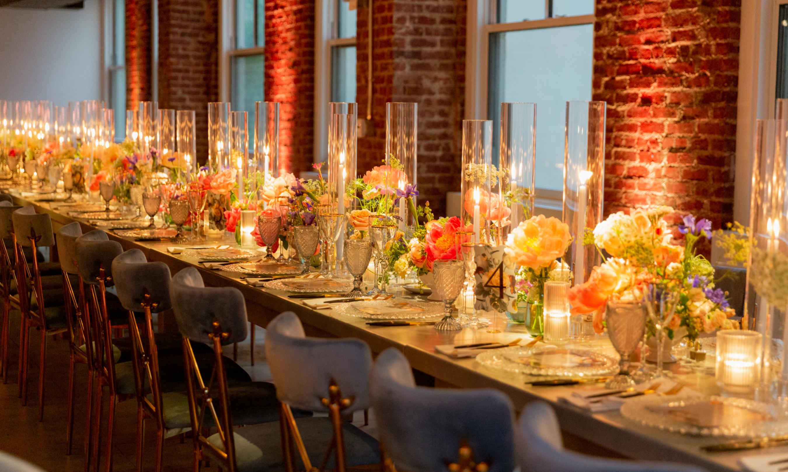 A table decorated with dinnerware, candles, and flowers