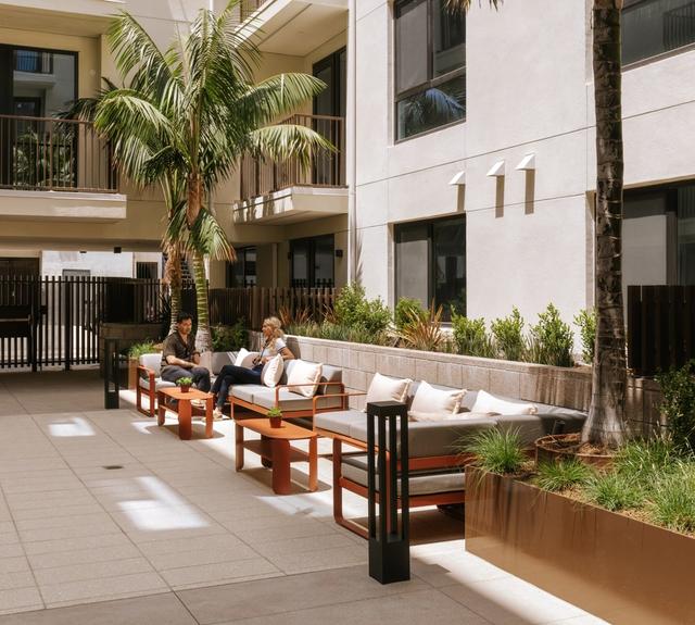 An open air courtyard with lush landscaping and inviting seating designed for gathering, unwinding, and enjoying the outdoors