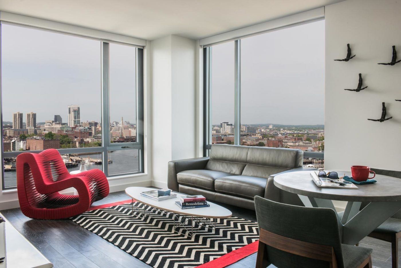 Model living room at The Eddy Apartments for rent in East Boston, featuring floor to ceiling windows.
