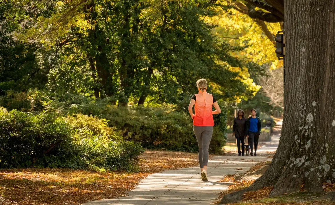 Woman enjoys a run and couple walk their dog in their Washington, DC neighborhood