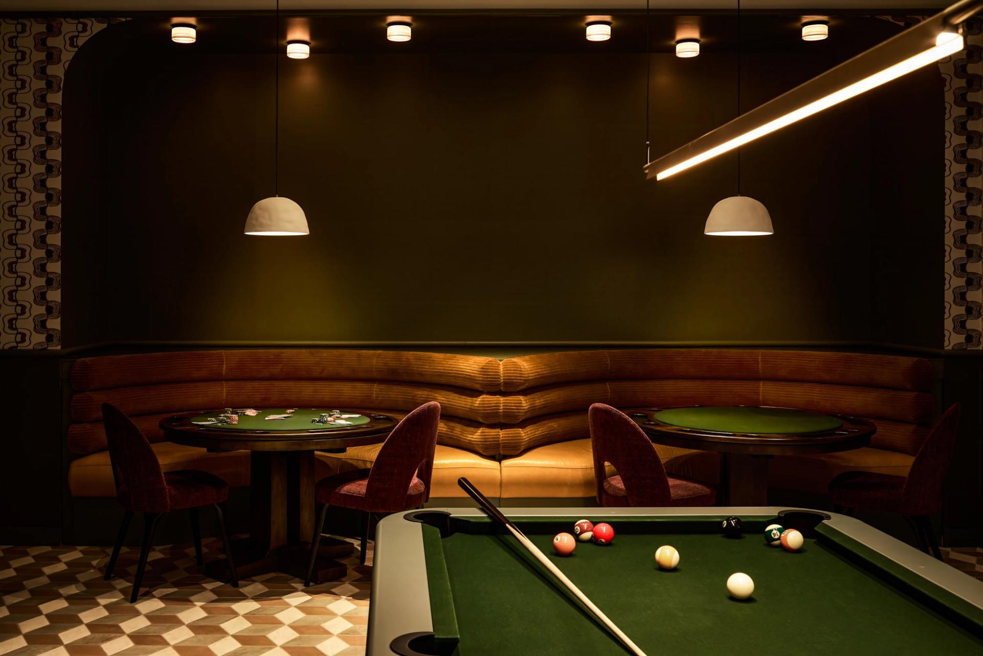 Resident lounge at Verra Apartments for rent in Boston, featuring a billiards table and booth seating.