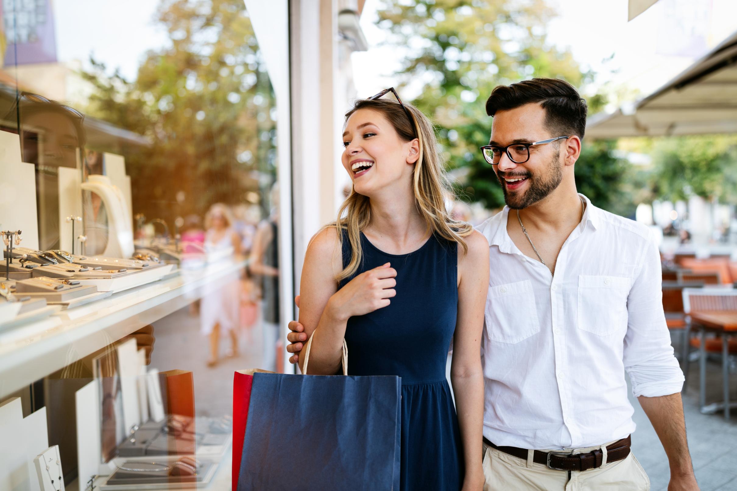 Two people glancing into a boutique shop while walking 