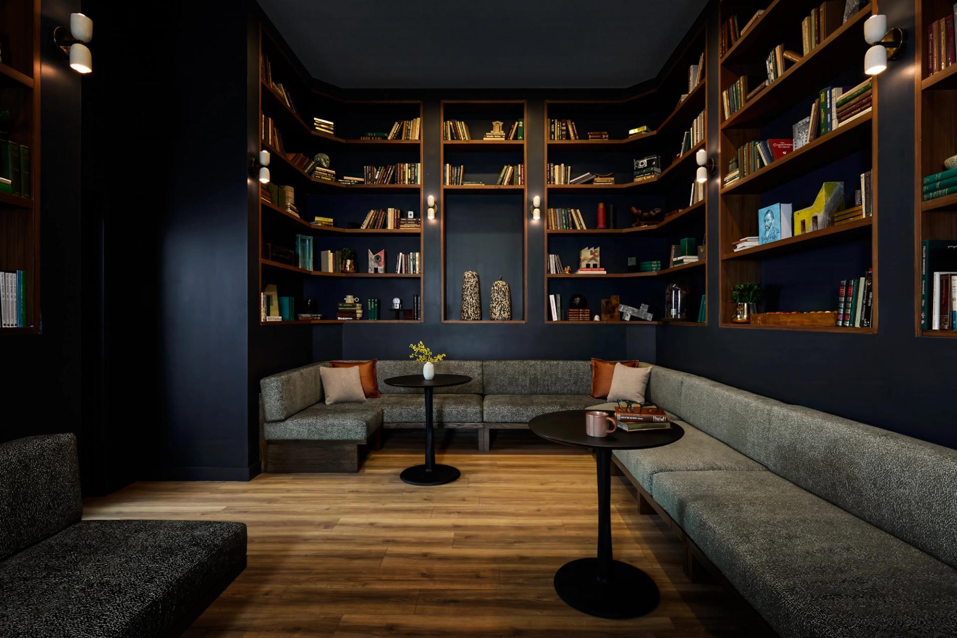 Resident lounge at Verra Apartments for rent in Boston, featuring book shelves with pottery and bench seating.