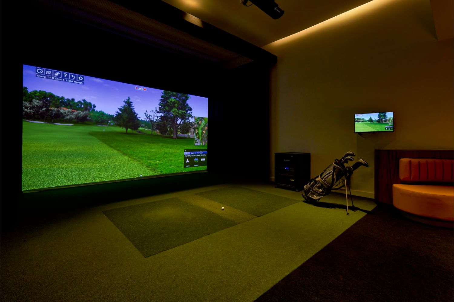 Man practices golf swing in the games simulator lounge in the Residences at Mazza
