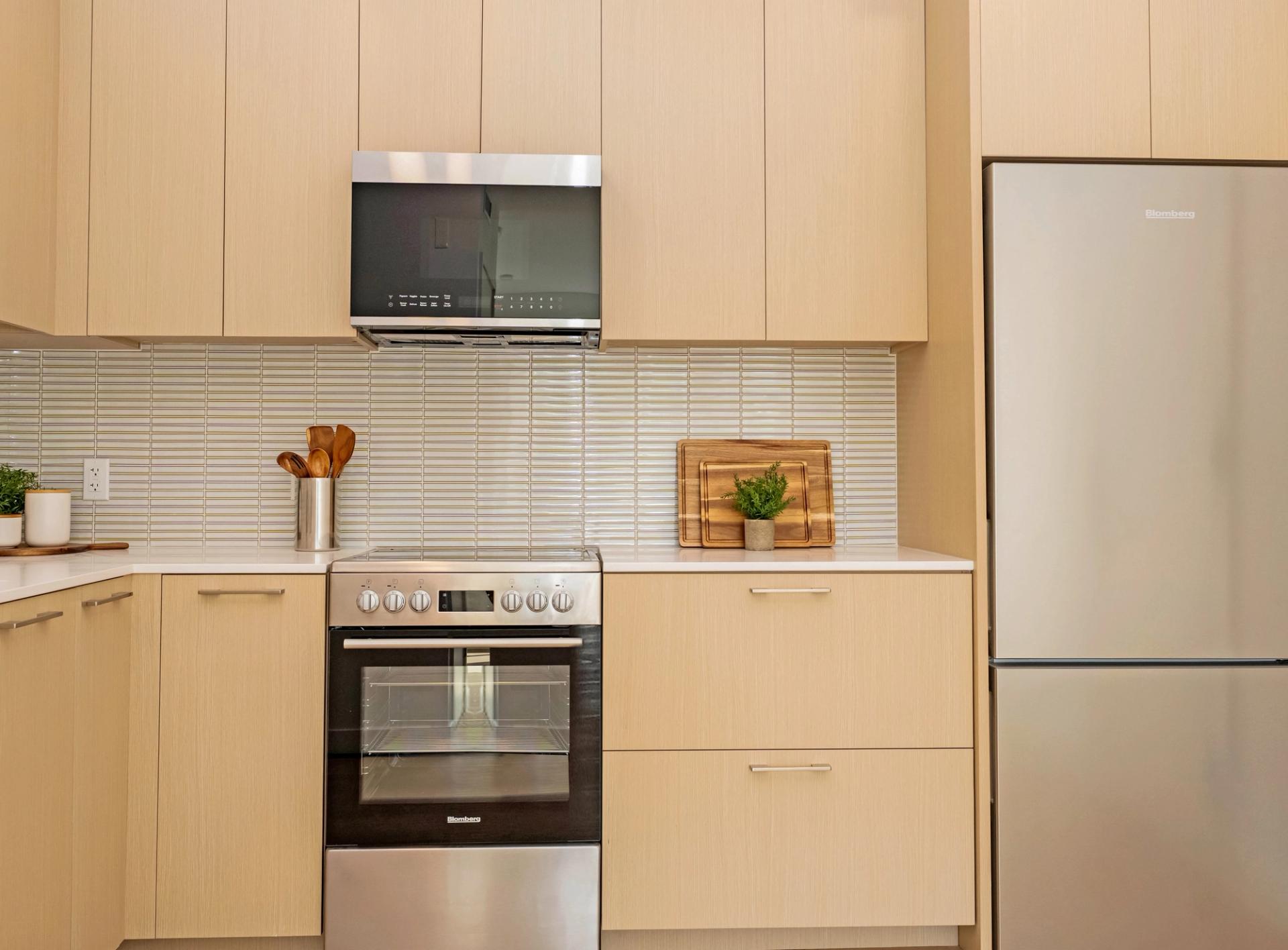 Kitchens with white oak cabinetry, mosaic tile backsplash, and stainless appliances