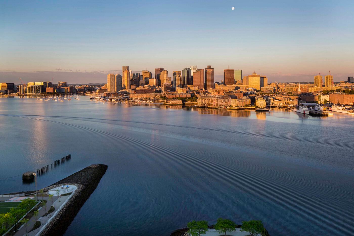 The Boston city skyline seen from The Eddy Apartments for rent in East Boston, featuring skyscrapers in golden light.