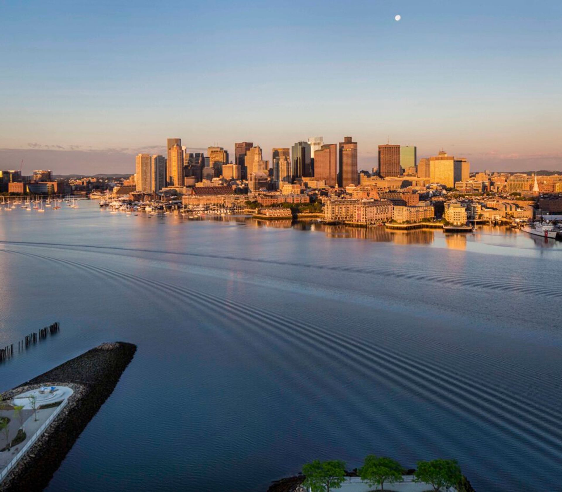 The Boston city skyline seen from The Eddy Apartments for rent in East Boston, featuring skyscrapers in golden light.