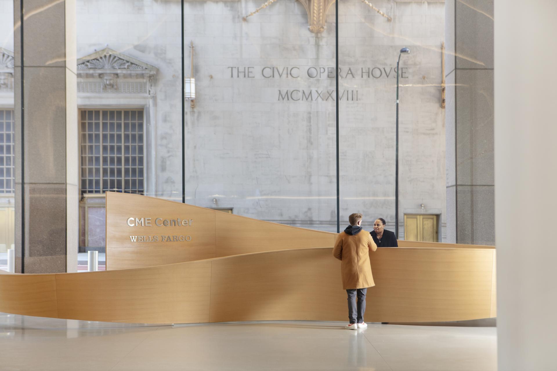 The lobby of the New York City Museum features a modern, sleek wooden reception desk with a curved design, inviting visitors to interact with the museum's exhibits.