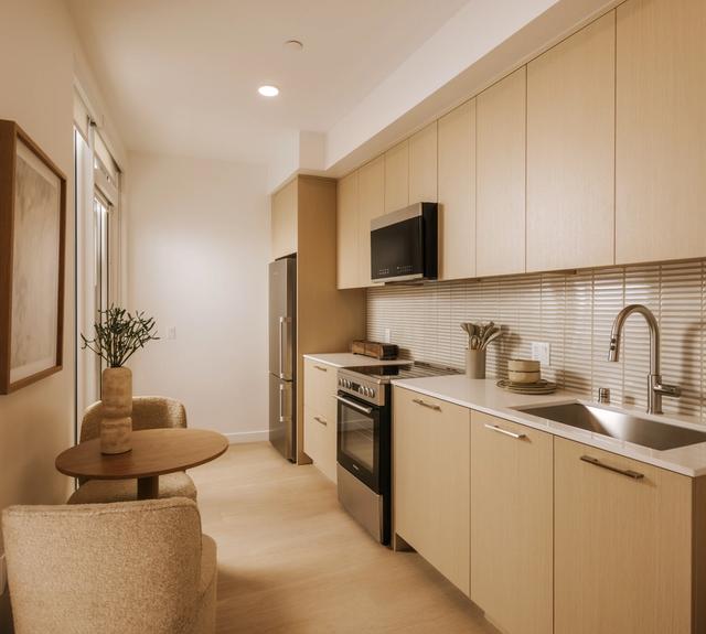 Kitchens with white oak cabinetry, mosaic tile backsplash, and stainless appliances