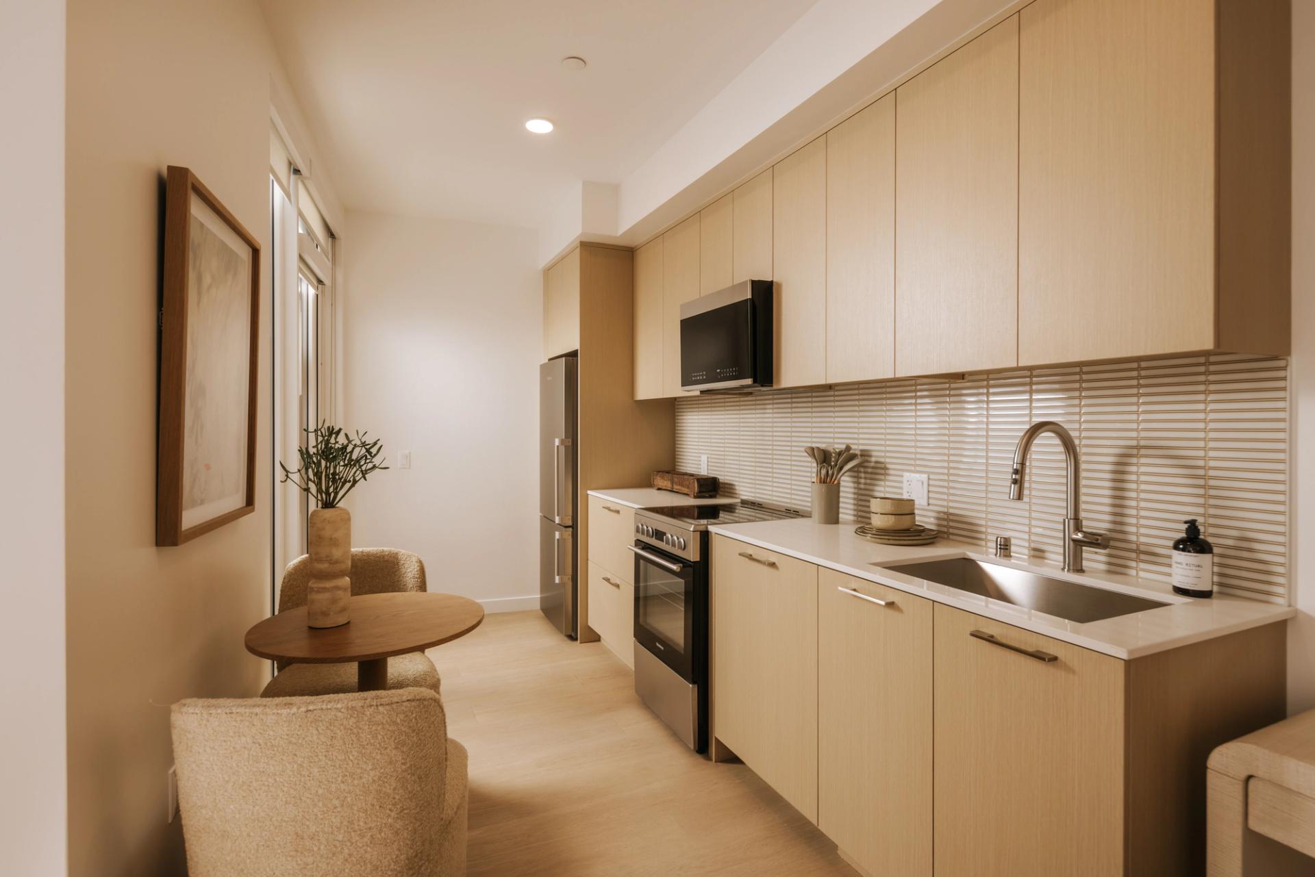 Kitchens with white oak cabinetry, mosaic tile backsplash, and stainless appliances