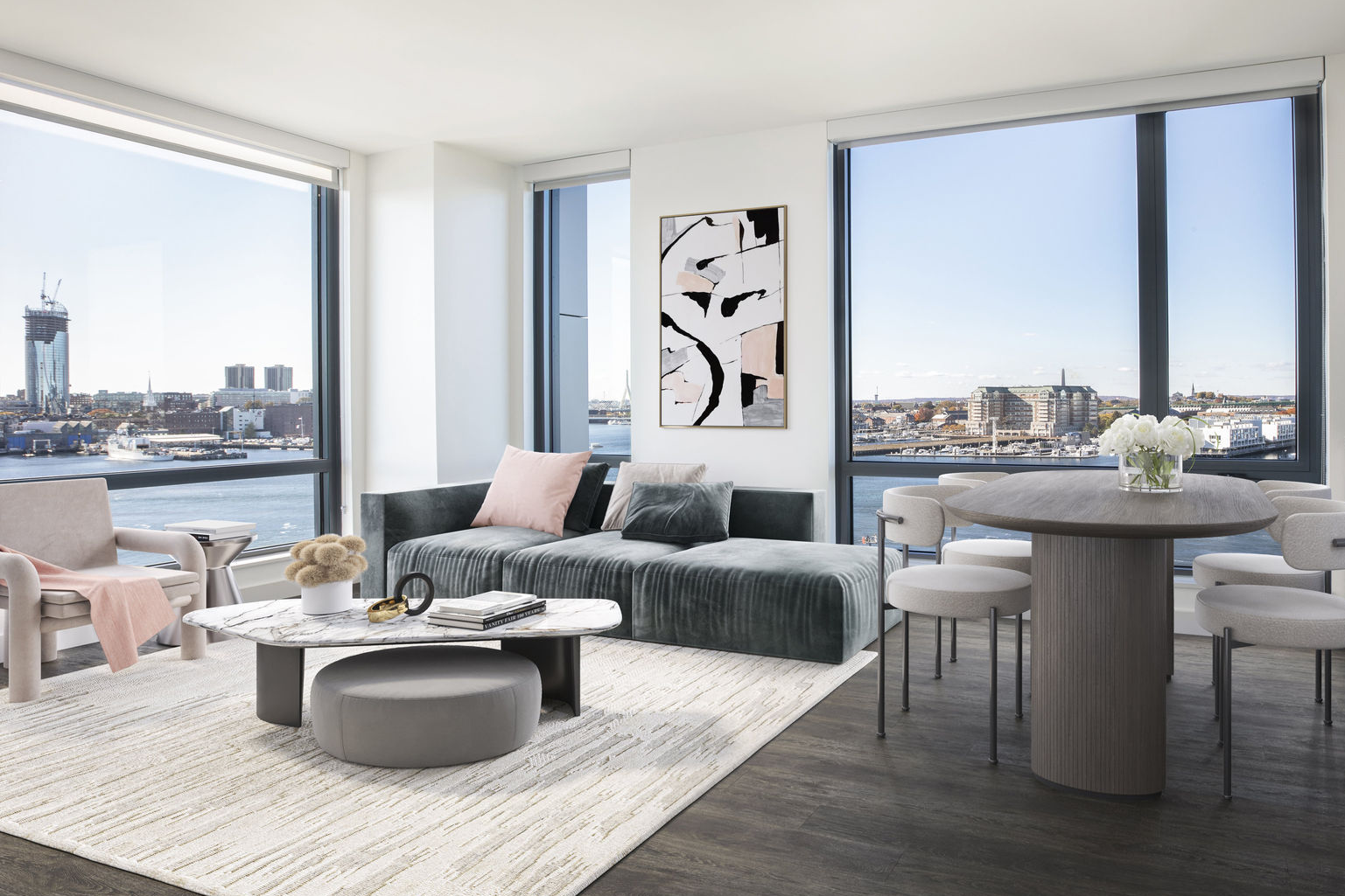 Model living room at The Eddy Apartments for rent in East Boston, featuring floor to ceiling windows and wood grain flooring.