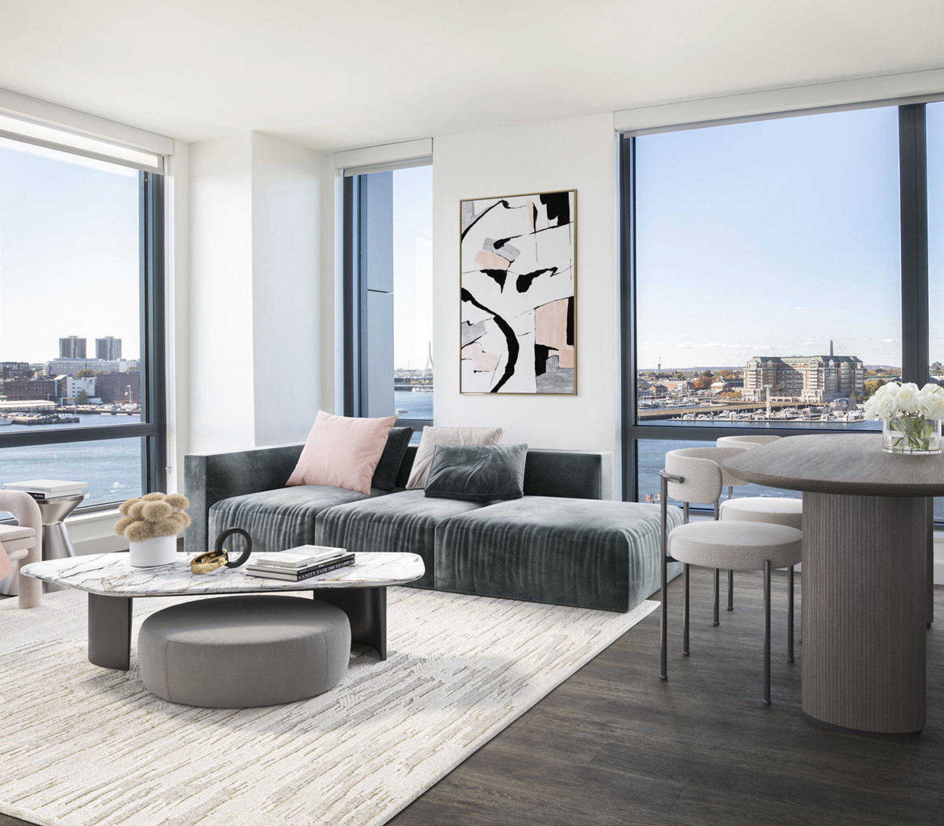 Model living room at The Eddy Apartments for rent in East Boston, featuring floor to ceiling windows and wood grain flooring.