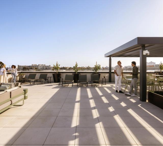 A rooftop designed for unwinding, with generous lounge seating set in a soft, green surround