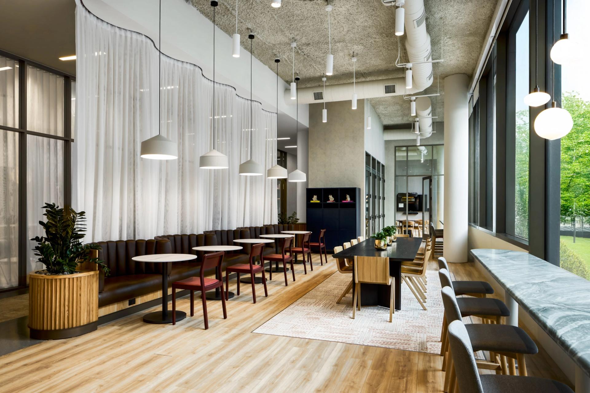 Resident lounge at Verra Apartments for rent in Boston, featuring wood grain flooring and ample seating.