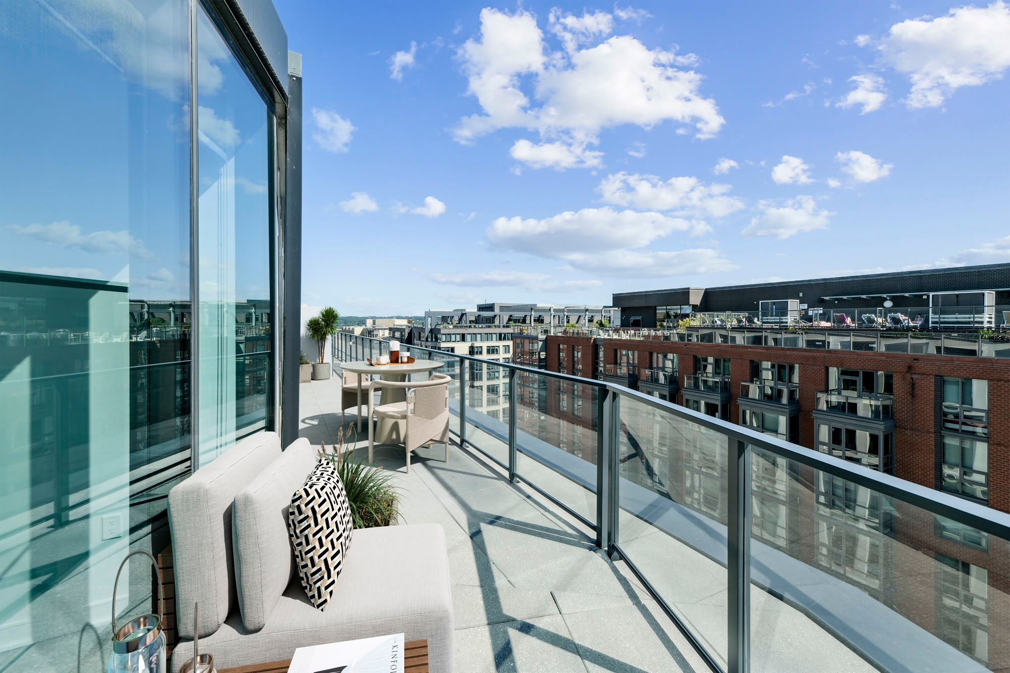 Model balcony at Crossing DC apartments in Navy Yard, featuring outdoor furniture and a view of the city.