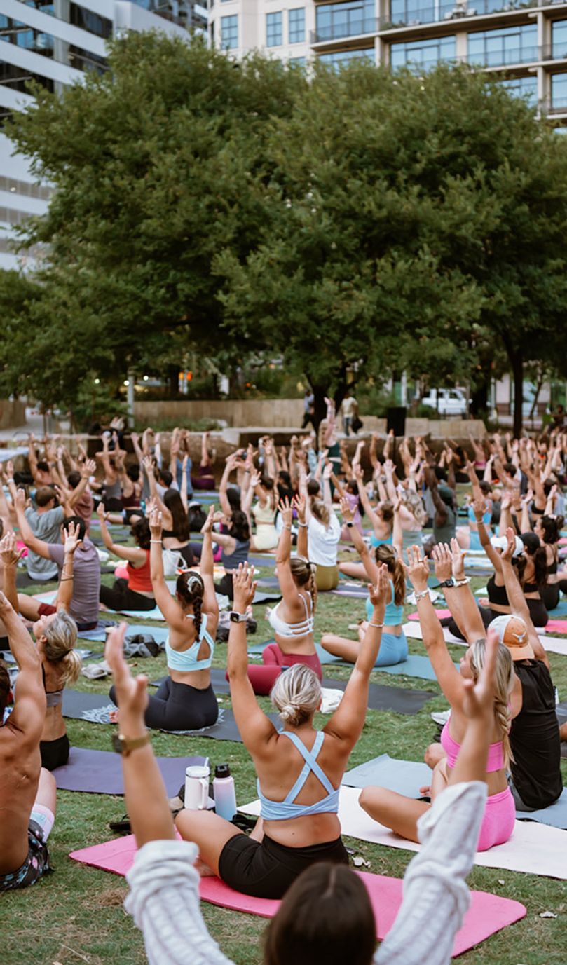 A large group of people doing yoga in a park