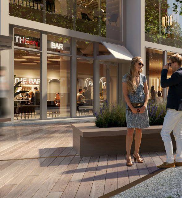the ground floor retail and dining area of the Brannan Square campus in SoMa, featuring modern glass storefronts and a wooden plaza.