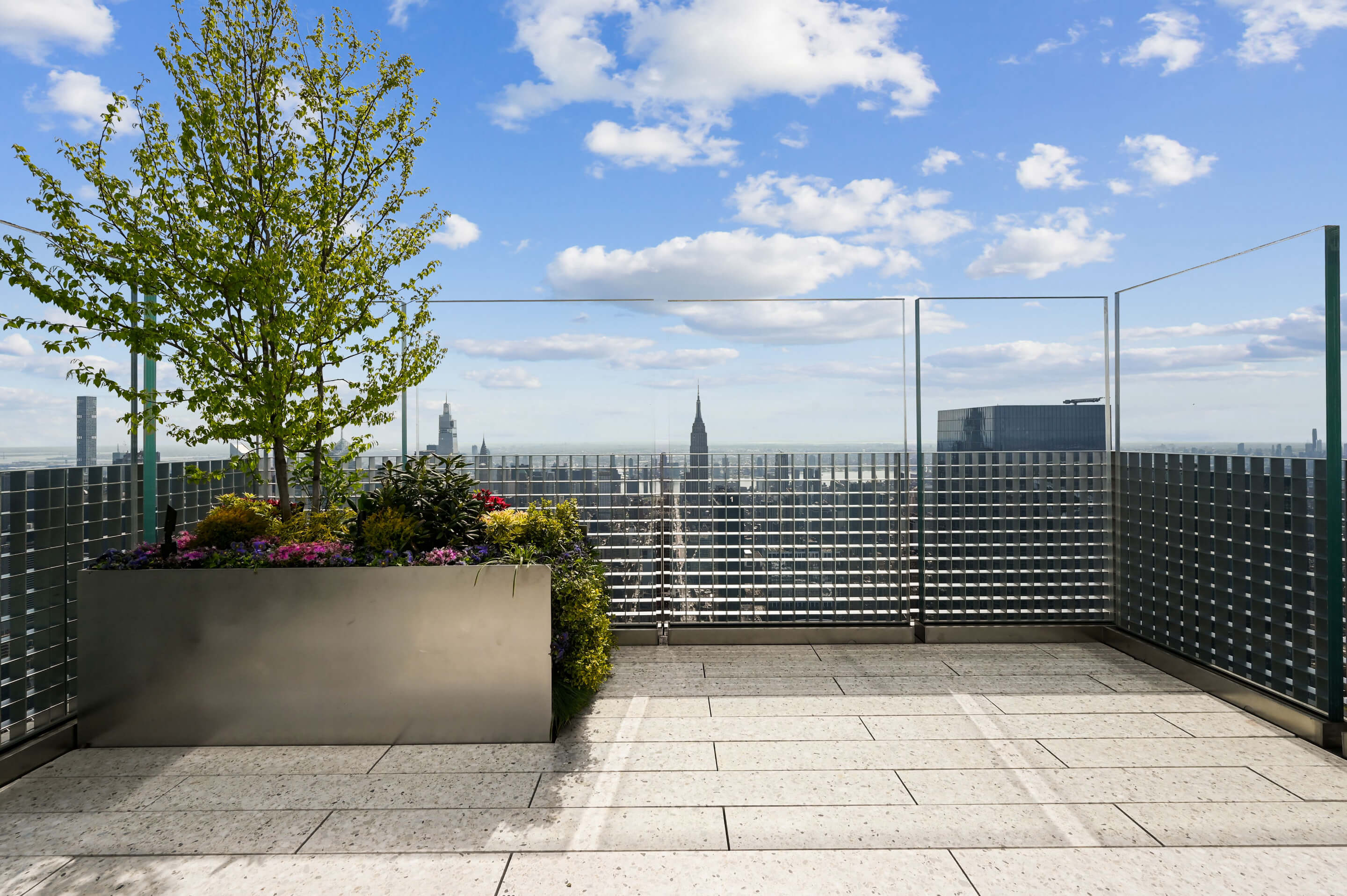 An open air terrace with a tree in the corner