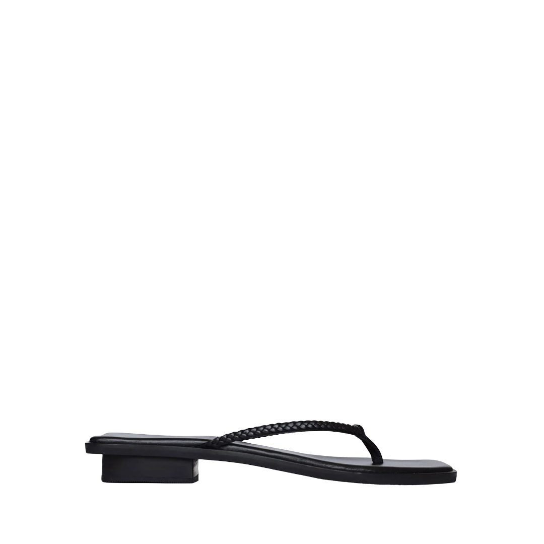Black flat sandals with a textured strap and a low block heel, displayed from the side against a plain background.
