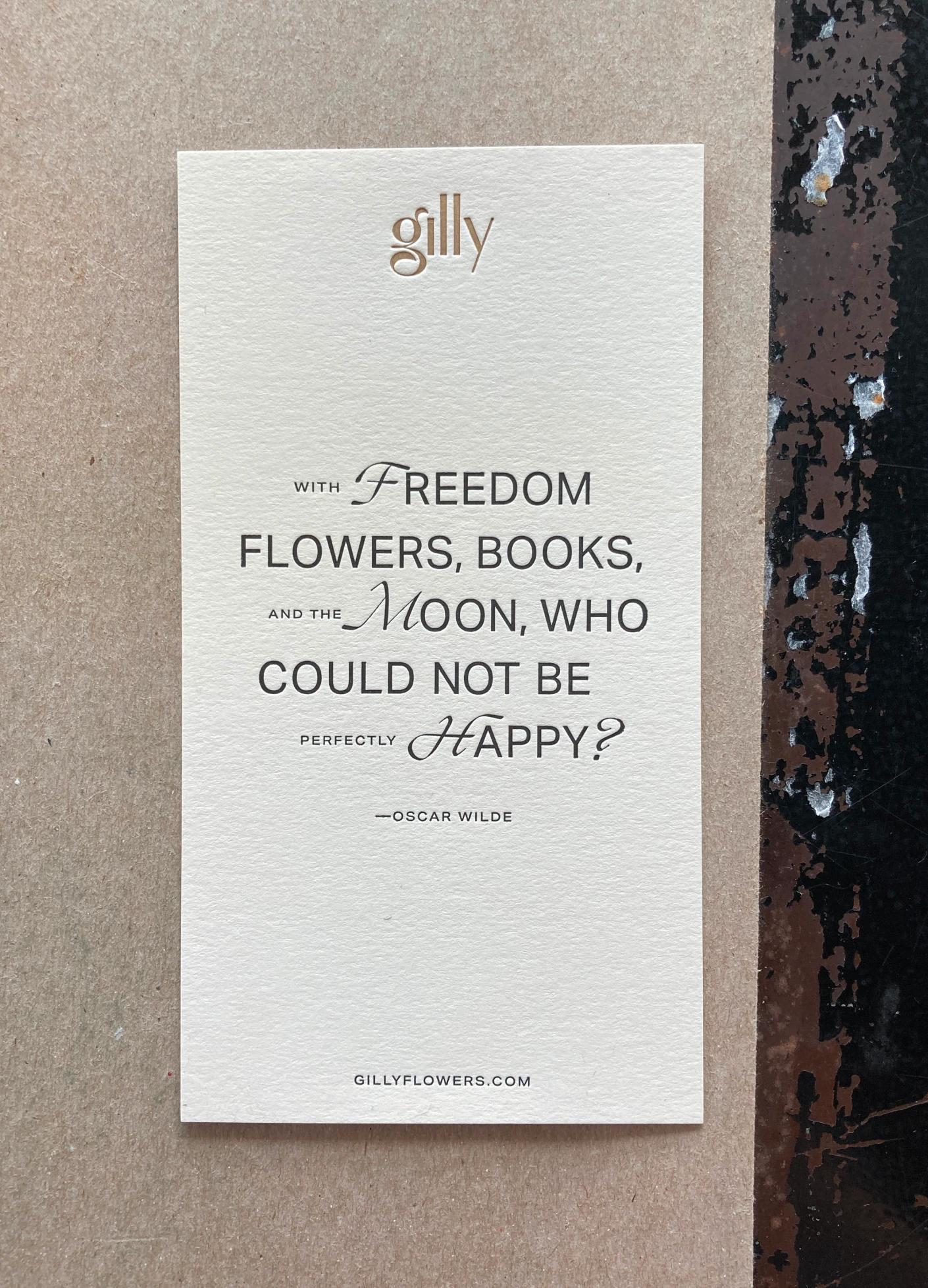 An elegant card with a quote by Oscar Wilde about happiness, printed on textured beige paper with a website link.