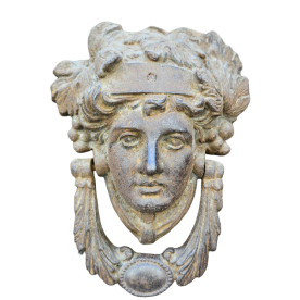 Ancient stone relief depicting a female face adorned with a crown and surrounded by decorative foliage.