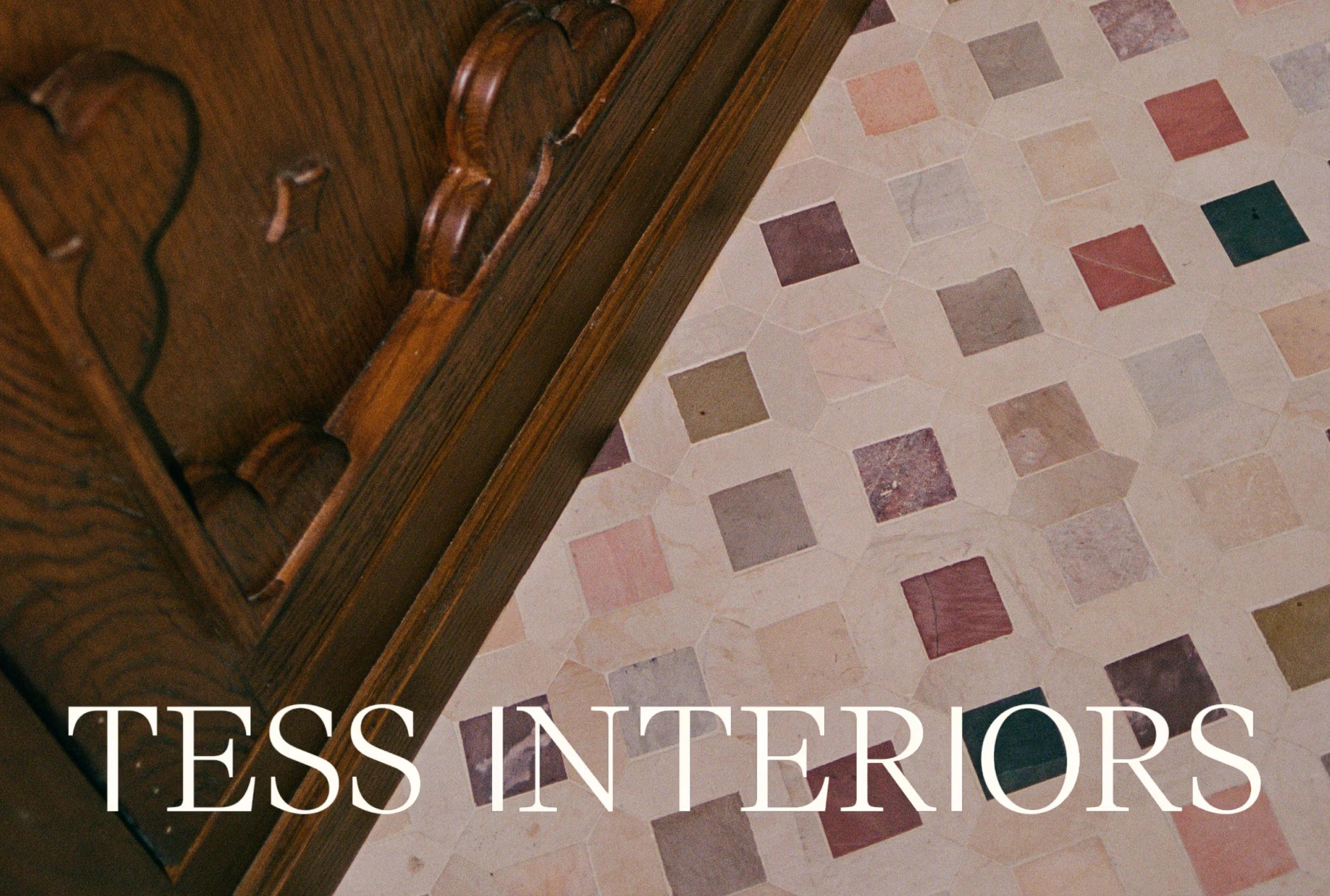 Wooden furniture corner above a decorative tiled floor with pastel geometric patterns, featuring the text "TESS INTERIORS."