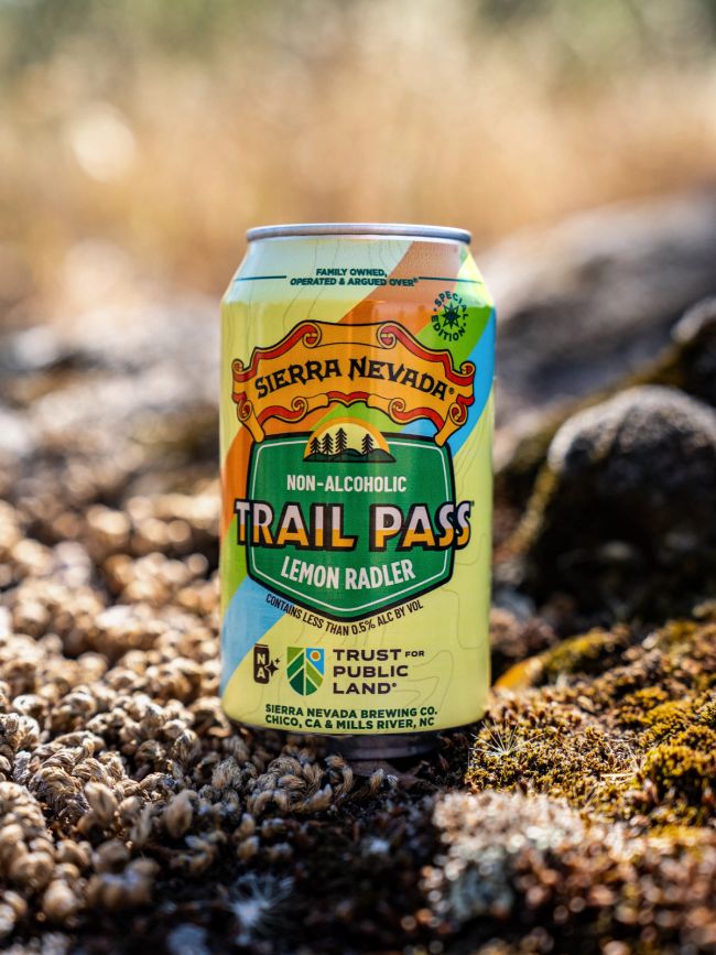 A can of non-alcoholic Trail Pass Lemon Radler in an outdoor setting
