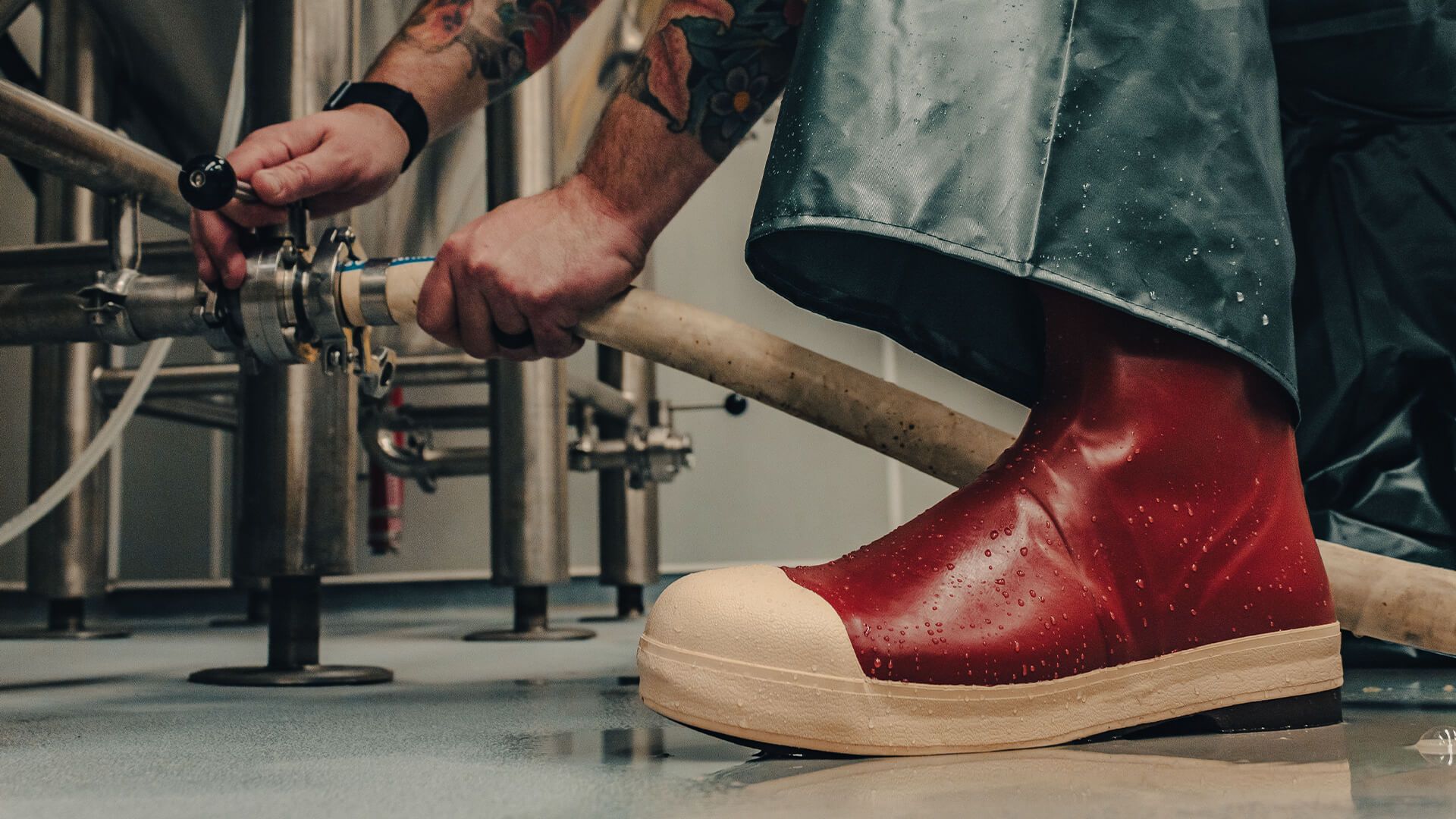 man working in brewery wearing tingely boots