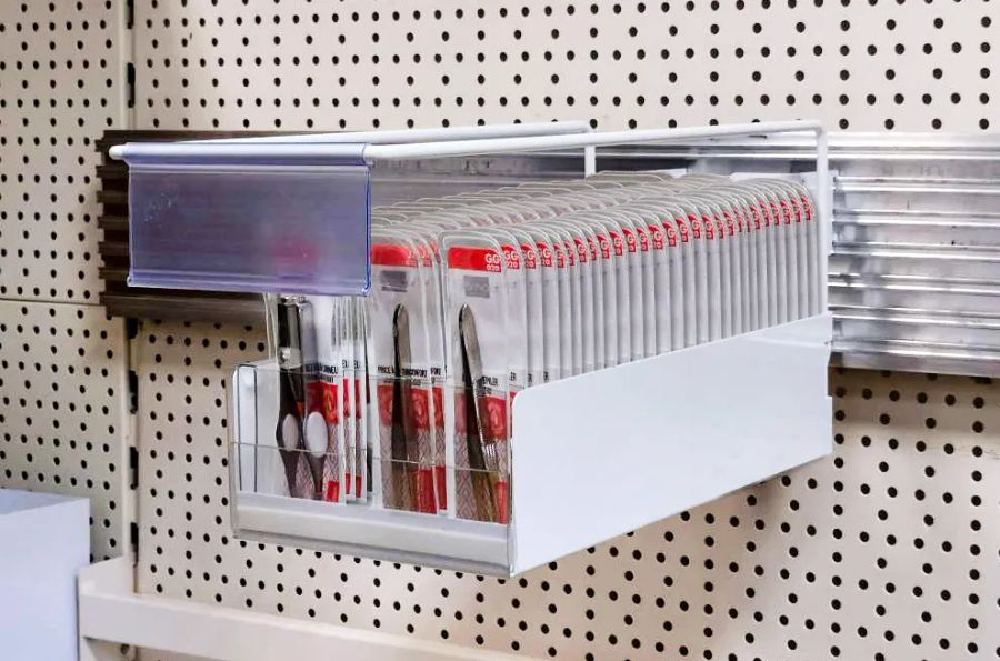 White wall tray filled with packaged tweezers