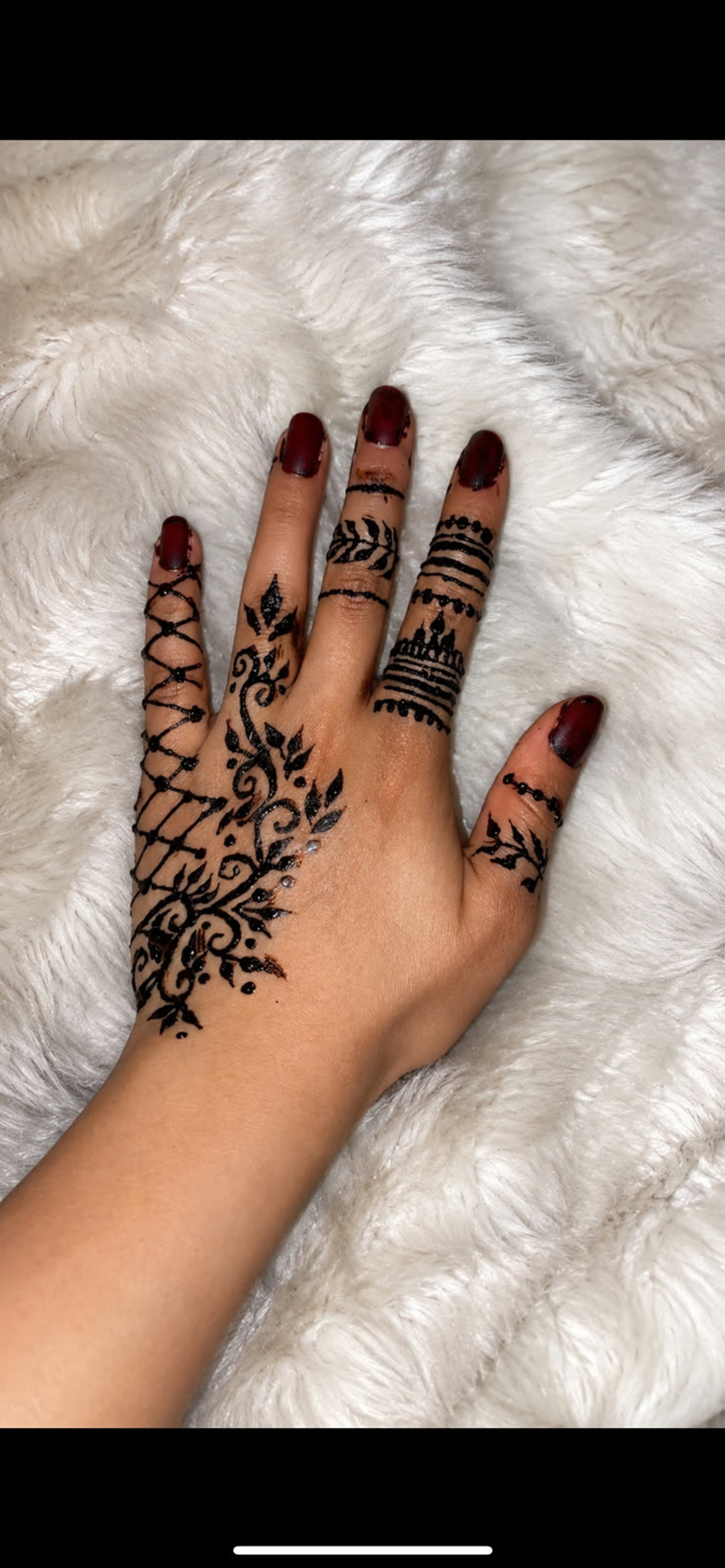 Black henna floral trailing down the back of the hand and fingers